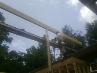 Carpenter setting a ridge beam over a new addition frame — Ice Dam Removal by Roofing Brothers in Blue Mound
