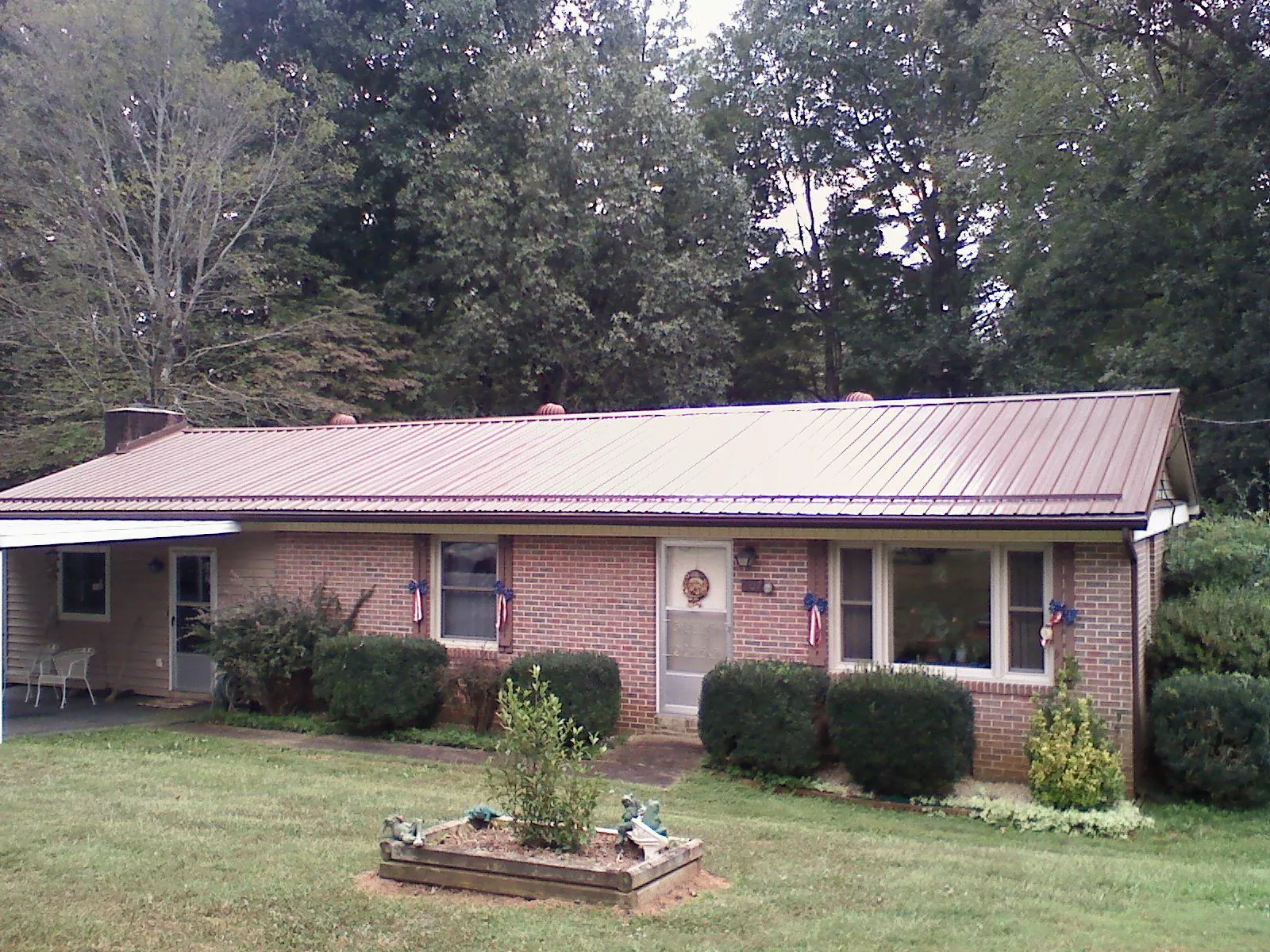 Bronze metal roof on a brick ranch home with a carport in Blue Mound