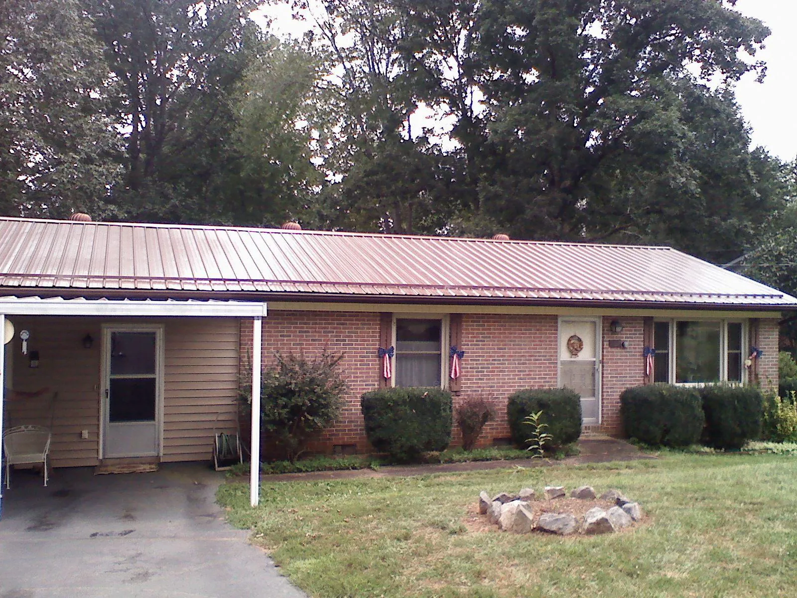 Bronze metal roof and carport on a brick ranch home — Roof Repair work by our crew in Blue Mound